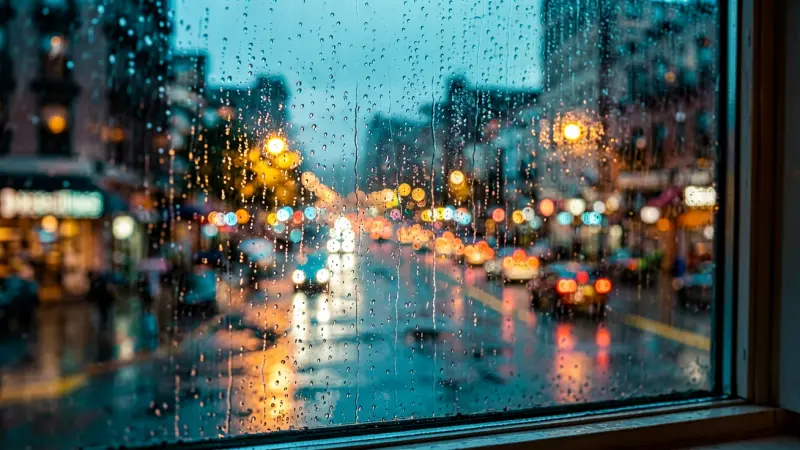 Rainy window pane with blurred city lights