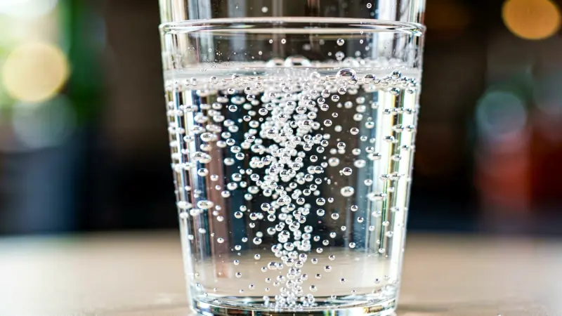 Close up of clear soda liquid in glass showing carbonation bubbles